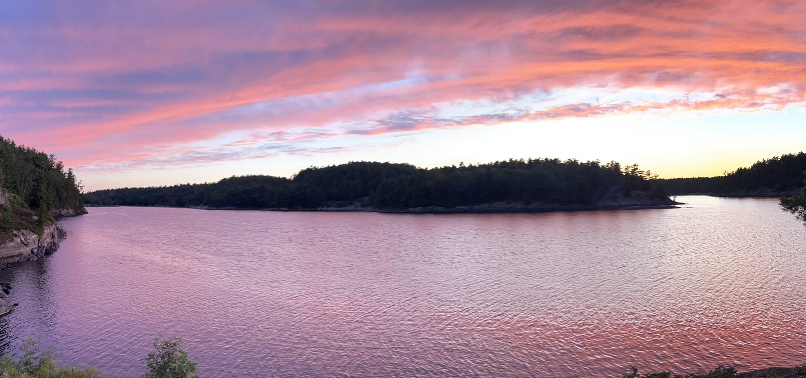 Pink and purple sunset over the water seen from campsite 687 in the French River Delta