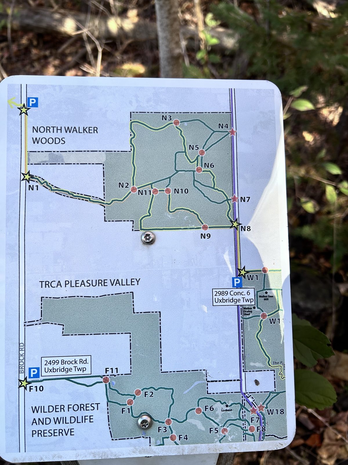 A trail map board at the North Walker Woods trailhead showing North Walker Woods, TRCA Pleasure Valley and Wilder Forest and Wildlife Preserve, with numbered junctions and parking on Concession 6 and Brock Road